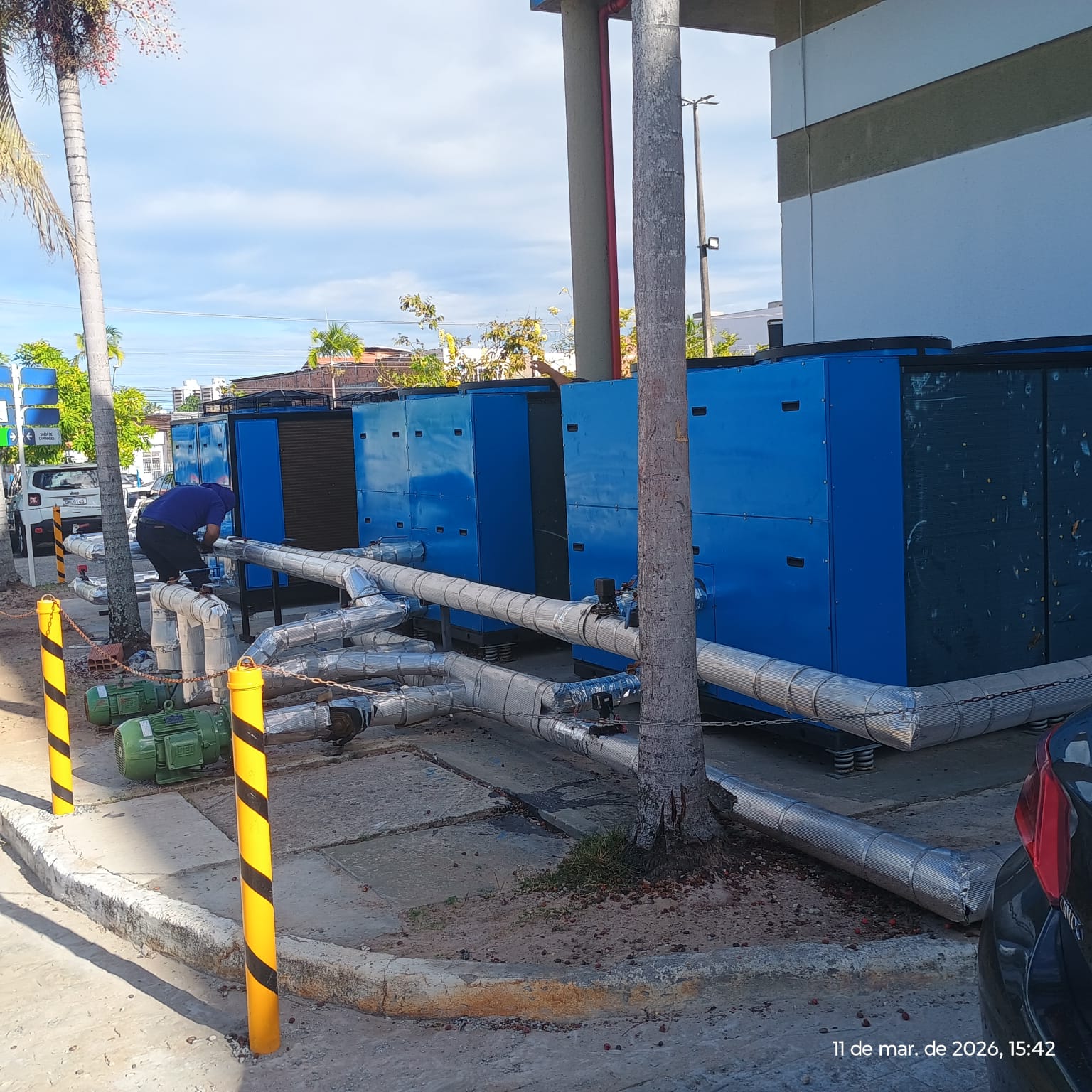 Profissional junto a uma instalação de chillers e tubulações